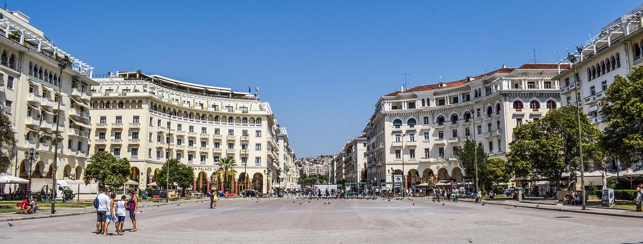 Platz der Demokratie, Thessaloniki, großer Platz mit Häuserensemble bei Tage, Sonnenschein, Menschen