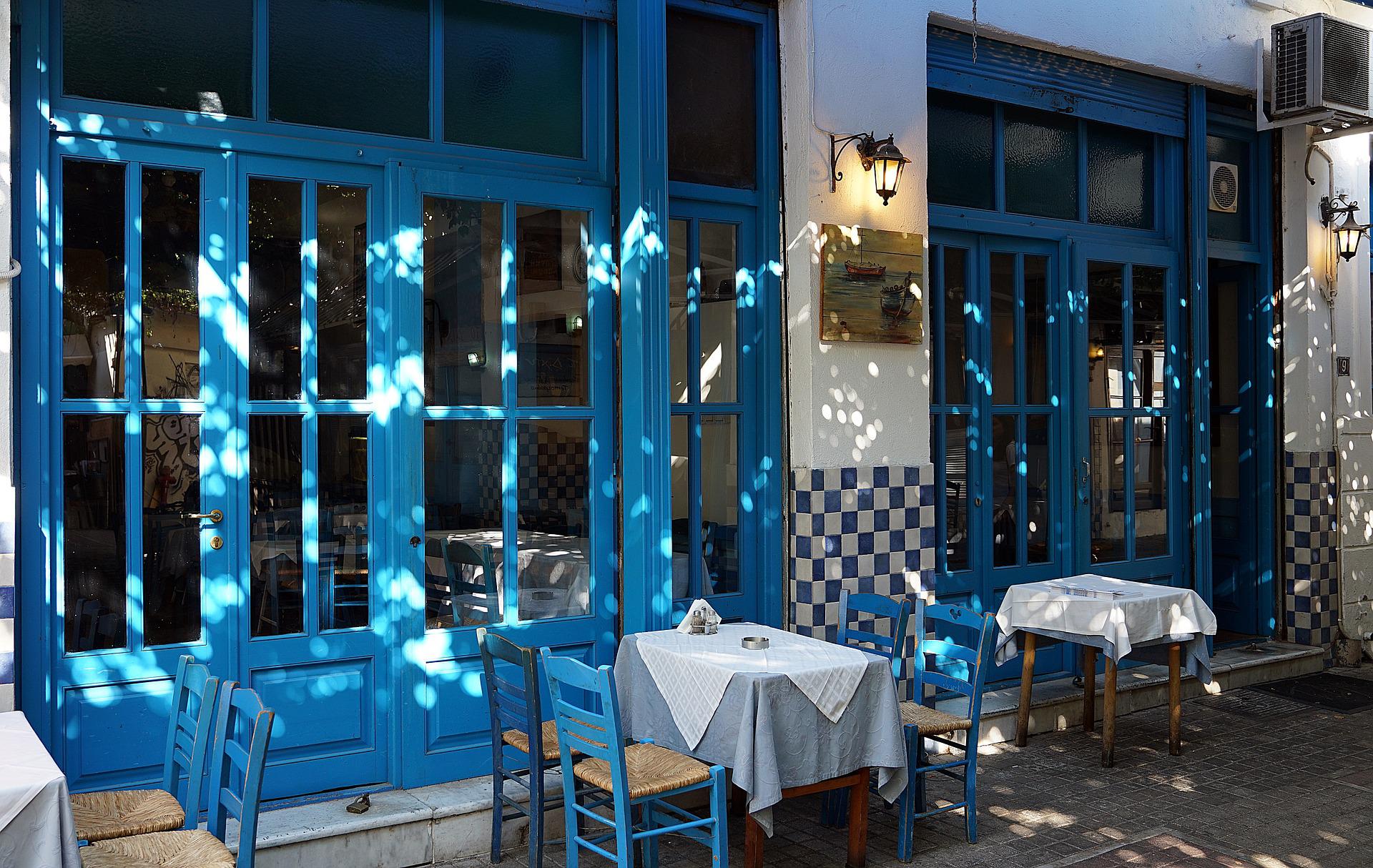 griechisches Restaurant, Symbolbild, blaue Stühle und weiße Tischdecken