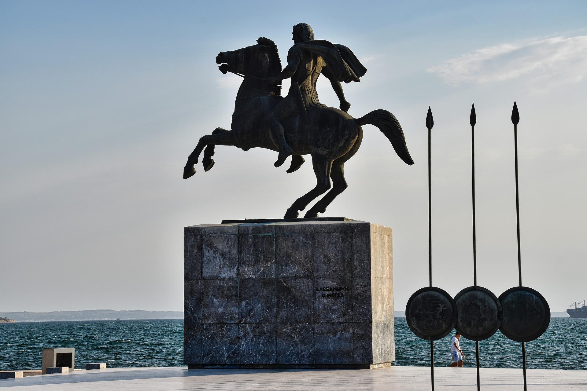 Bronzestatue Alexander des Großen auf Steinsockel am Meer, rechts drei Speere und Schilder, Künstler Evangelos Mustafas, 1974 aufgestellt 