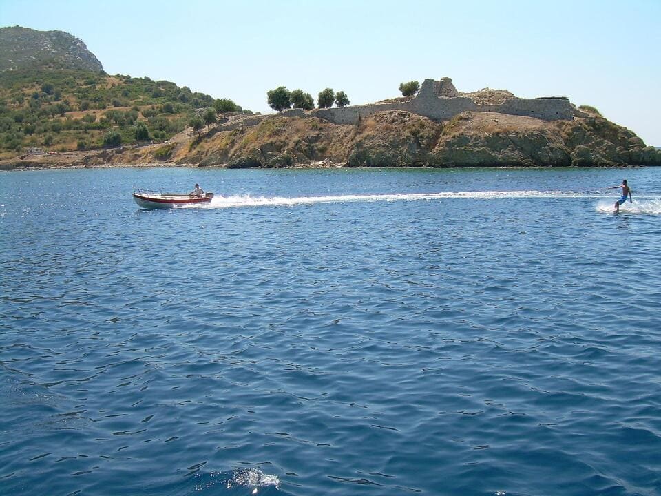 Meer bei Chalkidiki, Sportboot mit Wasserskifahrer, Ufer mit mediterraner Bepflanzung