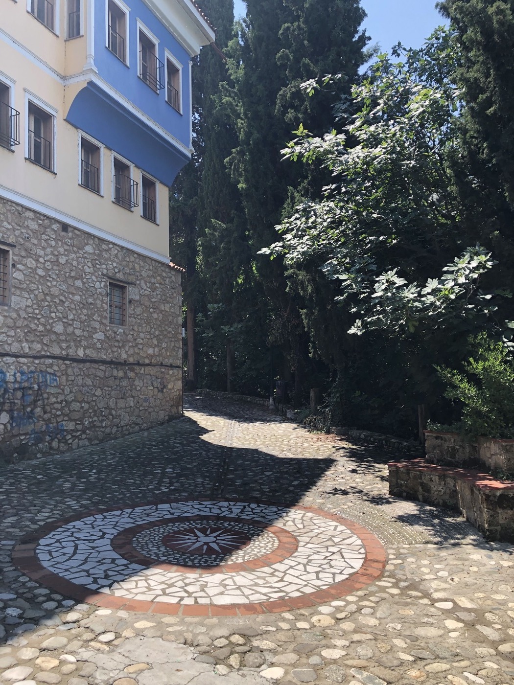 kleiner Platz, Kopfsteinpflaster, Mosaik mit makedonischer Sonne, Imathia erleben und genießen